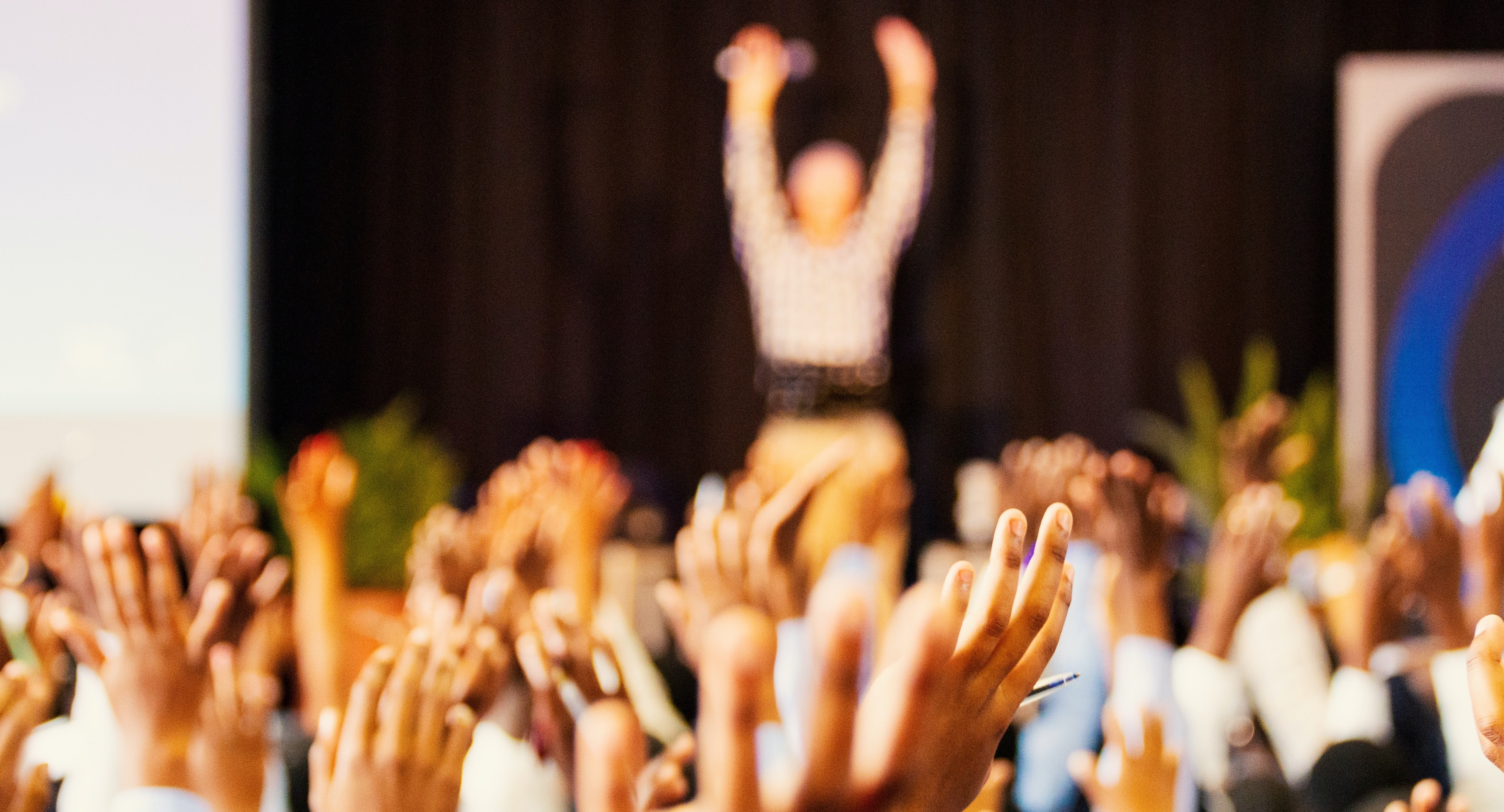 Konferenz mit vielen Teilnehmern und einem Redner, der mit ihnen interagiert